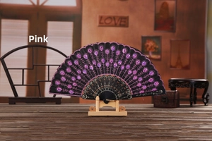 Detailed embroidery of pink peacock sequins and lace trim on a black folding fan