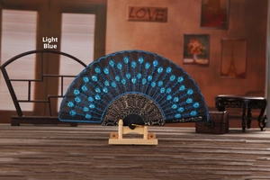 Close-up of light blue sequined peacock feather embroidery on a black folding fan