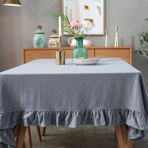 Detail showing the gray ruffle edge and textured linen blend fabric of the tablecloth