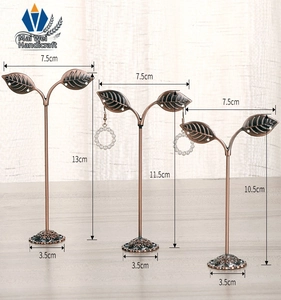 Three sizes of leaf-shaped metal earring stands with bronze finish and vintage base
