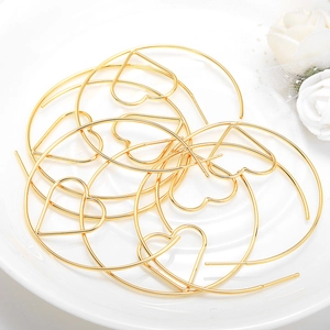 Golden heart-shaped hoop earrings for women with minimalist metallic finish on white base