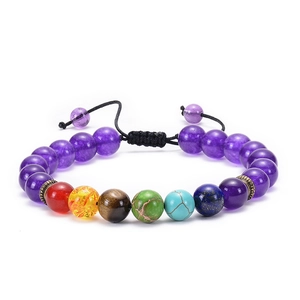 Close-up of chakra yoga bracelet with colorful natural stones and black woven cord