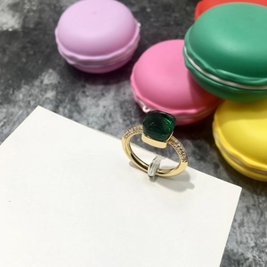 Detalle de anillo de esmeralda cuadrada con diamantes laterales y banda de metal dorado