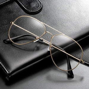 Classic gold aviator glasses with thin metal frame and clear lenses on black leather