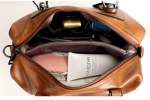 Detailed interior view showing compartments and storage capacity of brown leather bag