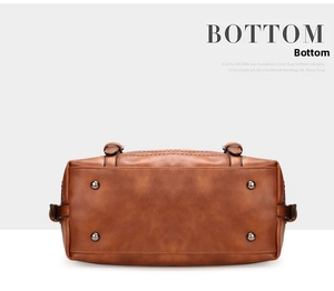 Detailed bottom view of brown Boston bag featuring four metal protective base studs