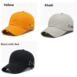 Detail of cotton baseball caps in yellow and khaki with metal ring and embroidered straps