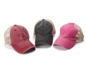 Detail of vintage washed cotton trucker hats showing breathable mesh and distressed textures