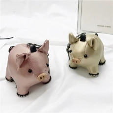 Close-up of metallic faux leather pig charms with black stitching and metal rings