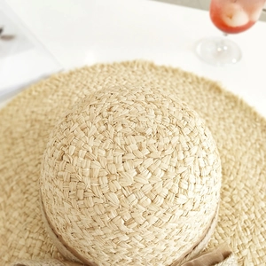 Natürlicher Raffia-Strohhut mit braunem Schleifenband und breiter Krempe für den Strandurlaub