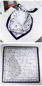 Detail of square silk scarf featuring a blue celestial star map design and vintage patterns