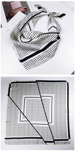 Flat lay of square silk scarf showing black and white polka dots and geometric patterns