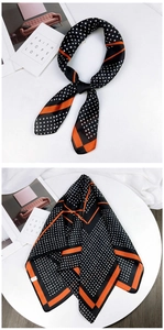 Detailed view of silk-like square scarf with black polka dots and orange striped borders