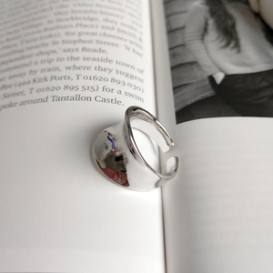 Minimalist wide irregular silver ring placed inside an open book for creative display