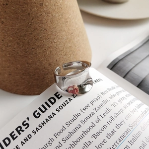 Close-up of minimalist irregular wide silver ring with polished concave mirror finish