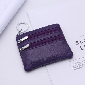 Close-up of dark purple pebbled leather coin purse with double zippers and metal keyring