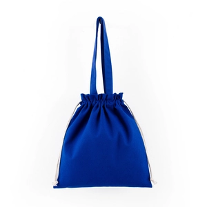Detail of blue canvas drawstring tote bag with contrasting cream ropes and fabric texture