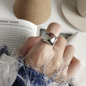Minimalist irregular wide silver ring with mirror finish on model wearing blue sweater
