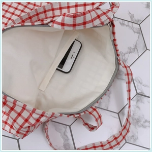 Vue détaillée de l'intérieur du sac en toile à carreaux rouge et blanc avec poche interne