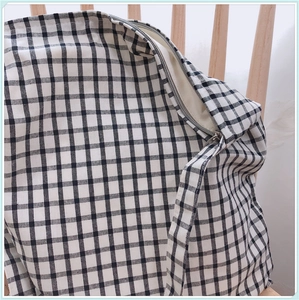 Détail du sac en toile à carreaux noir et blanc avec fermeture éclair en métal