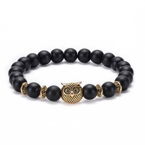 Detail view of 8mm matte black beads with a golden owl charm and vintage spacers