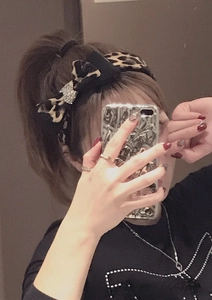 Close-up of leopard print headband featuring a sparkling rhinestone butterfly decoration