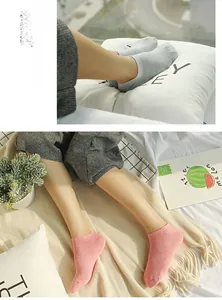 Detailed macro view of soft knit cotton ankle socks in light pink and grey tones