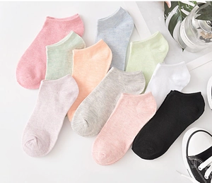 Flat lay of colorful cotton invisible socks in ten vibrant colors with a lifestyle setup