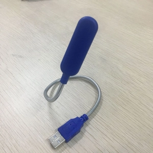 Blue portable USB LED night light with flexible metal hose on a light wood background