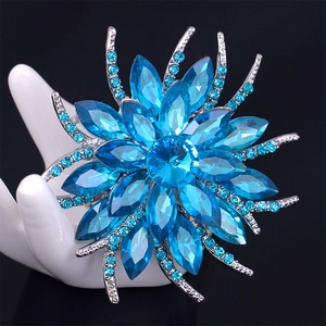 Blue crystal floral brooch in sunflower design with alloy setting on display stand