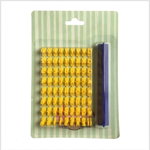 DIY baking tool set with yellow alphabet stamps and a blue handle tool in green packaging