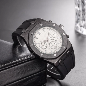 Close-up of black chronograph watch with octagonal bezel and rubber strap in a leather case