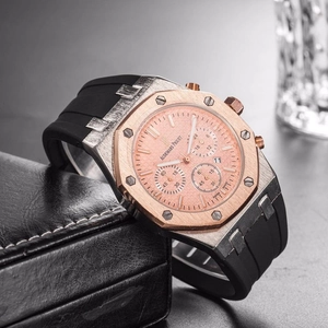 Detail macro shot of rose gold mechanical chronograph watch with black rubber strap