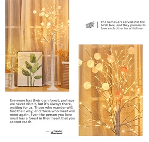 Detailed view of LED birch tree lamp with warm white lights and colorful cotton ball ornaments