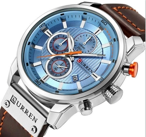 Detail view of CURREN quartz chronograph watch showing blue dial and brown leather strap