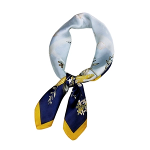 Elegant silk scarf featuring blue and yellow shell patterns with contrast stitched edges
