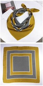 Close-up of mustard yellow square silk scarf with classic black and white polka dots
