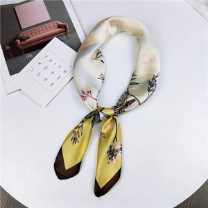 Elegant vintage floral and bird print satin silk scarf in yellow and cream on a pedestal
