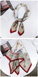 Detail of silk-texture square scarf with champagne gold floral patterns and red borders