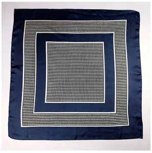 Macro detail of the navy blue polka dot silk scarf with elegant white linear borders
