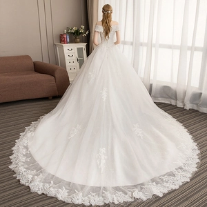 Elegant white off-the-shoulder wedding dress with long lace train and lace embroidery