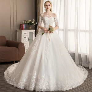 Elegant white lace wedding dress with off-shoulder neckline and intricate embroidery detail