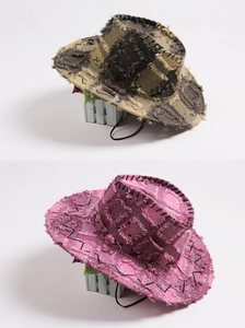 Detail of vintage western cowboy hats in brown and pink with frayed edges and chin cord