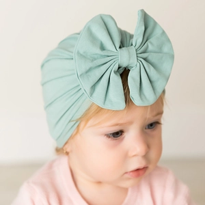 Soft mint green cotton baby turban hat with a large bow detail for newborn infants