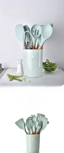 Mint green silicone kitchen utensil set with wooden handles in a matching storage bucket