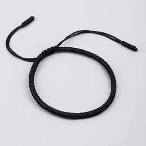 Close-up of black handcrafted braided cord bracelet with adjustable knot and twisted texture