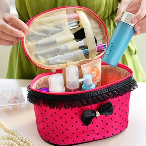 Detailed interior of rose pink polka dot makeup bag with lace trim and compartments