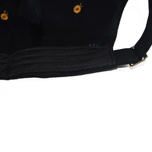 Detail view of cotton baseball cap with adjustable metal buckle and yellow embroidery
