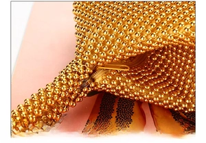 Close-up of golden beaded evening clutch bag featuring a high-quality metal zipper closure