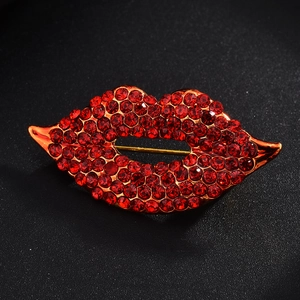 Macro shot of luxury crystal red lip brooch with sparkling rhinestones on black background